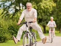 Un homme et une femme seniors sur des vélos dans un environnement verdoyant.