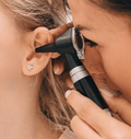 Professionnelle examinant l’oreille d’une patiente à l’aide d’un otoscope.