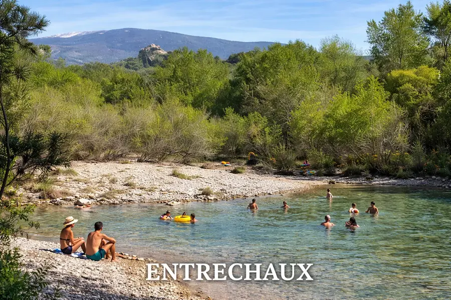 Baigneurs dans une rivière bordée de galets et d’arbres à Entrechaux.