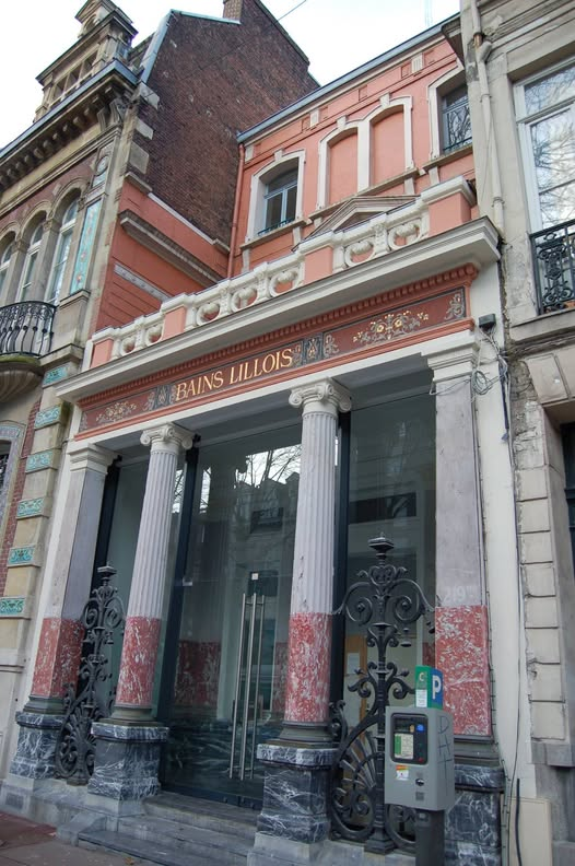 Façade historique des Bains Lillois boulevard de la Liberté à Lille, avec quatre colonnes roses, grilles décoratives et ancienne inscription Bains Lillois.