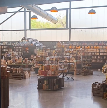 Vue d’ensemble de la halle gourmande avec ses étagères et ses présentoirs de produits.