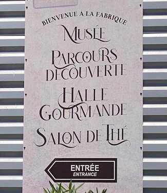 Panneau indiquant le musée, le parcours découverte, la halle gourmande et le salon de thé de la biscuiterie.