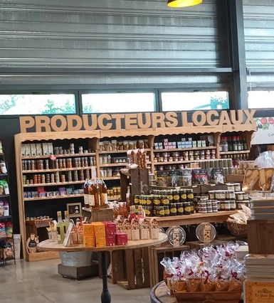 Rayon « Producteurs locaux » présentant des bocaux, des bouteilles et des paniers gourmands.