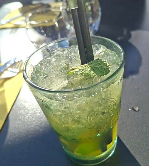 Verre de cocktail avec glaçons, feuilles de menthe et paille au Bistrotteur.