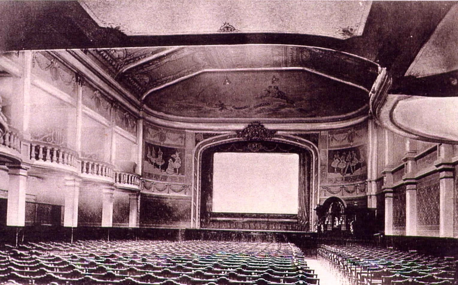 Intérieur historique du cinéma Le Mondial à Lille, salle à l'italienne avec fauteuils, galeries latérales, décors peints et grand écran de projection.