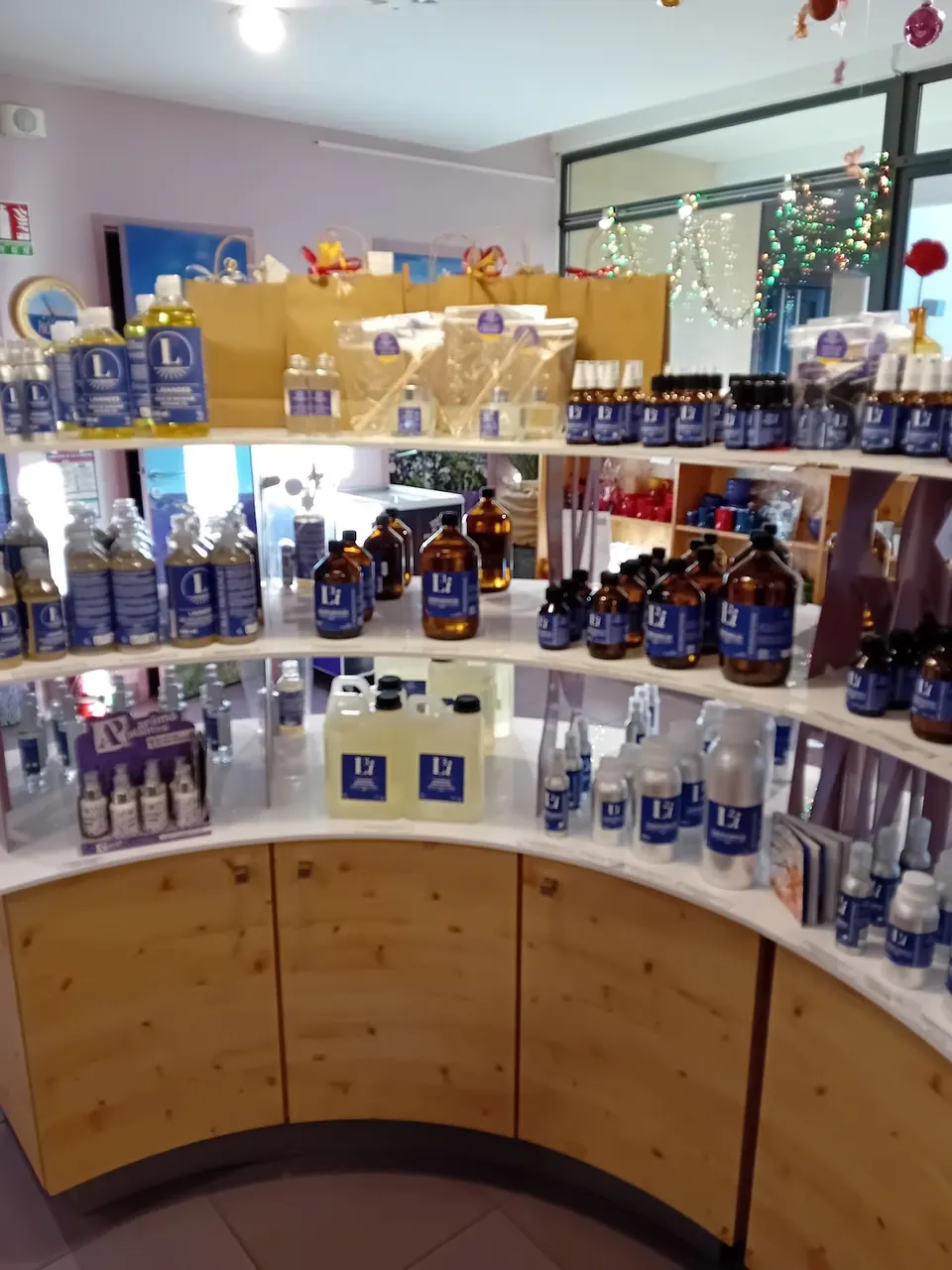 Flacons et produits présentés sur un comptoir courbe dans la boutique Bleu Provence.