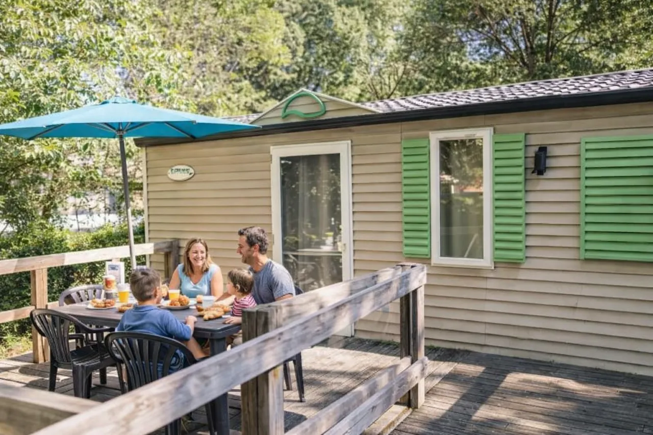 Famille en vacances sur la terrasse d’un mobil-home au camping Les Clos près de Nyons, dans un cadre calme et ombragé.