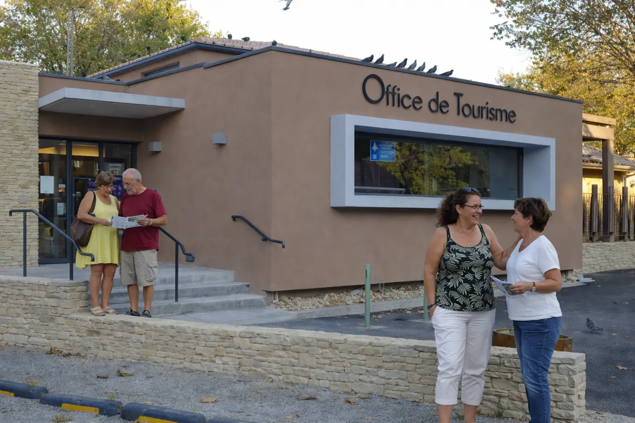 Devant l’Office de Tourisme de Nyons, des visiteurs consultent un plan et échangent des informations avant de partir découvrir la ville.