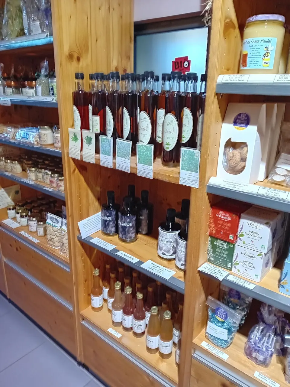 Bouteilles et produits gourmands sur les étagères en bois de la boutique Bleu Provence.