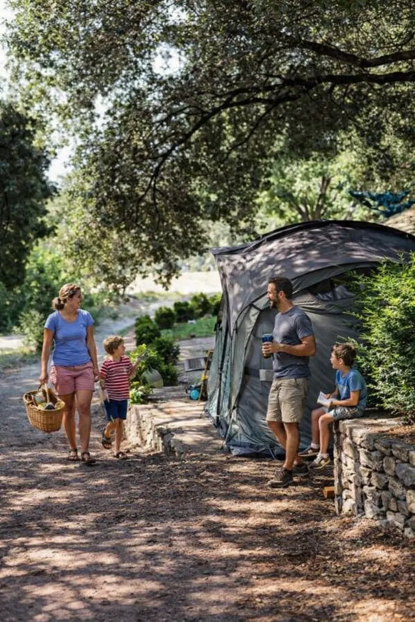 Famille installée en tente au camping à la ferme Brès près de Nyons, sous les arbres et au calme.