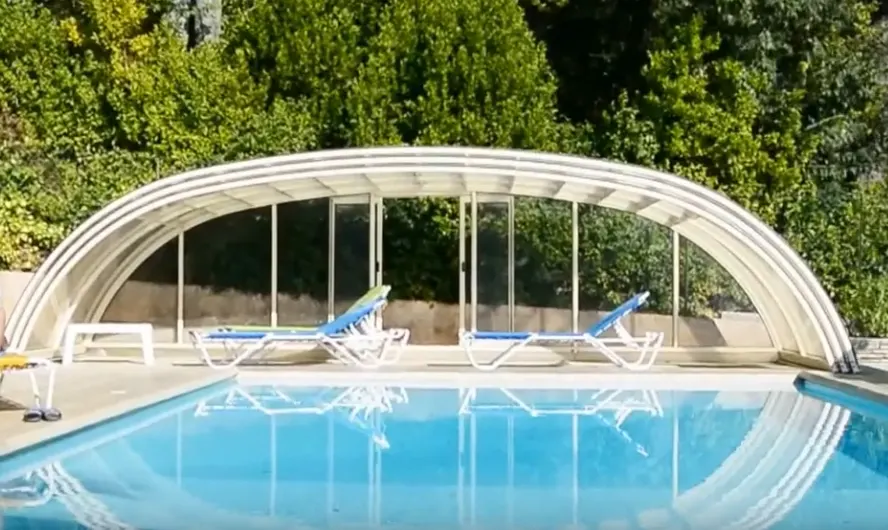Vue de la piscine de La Lézardière et de son abri arrondi dans le jardin.