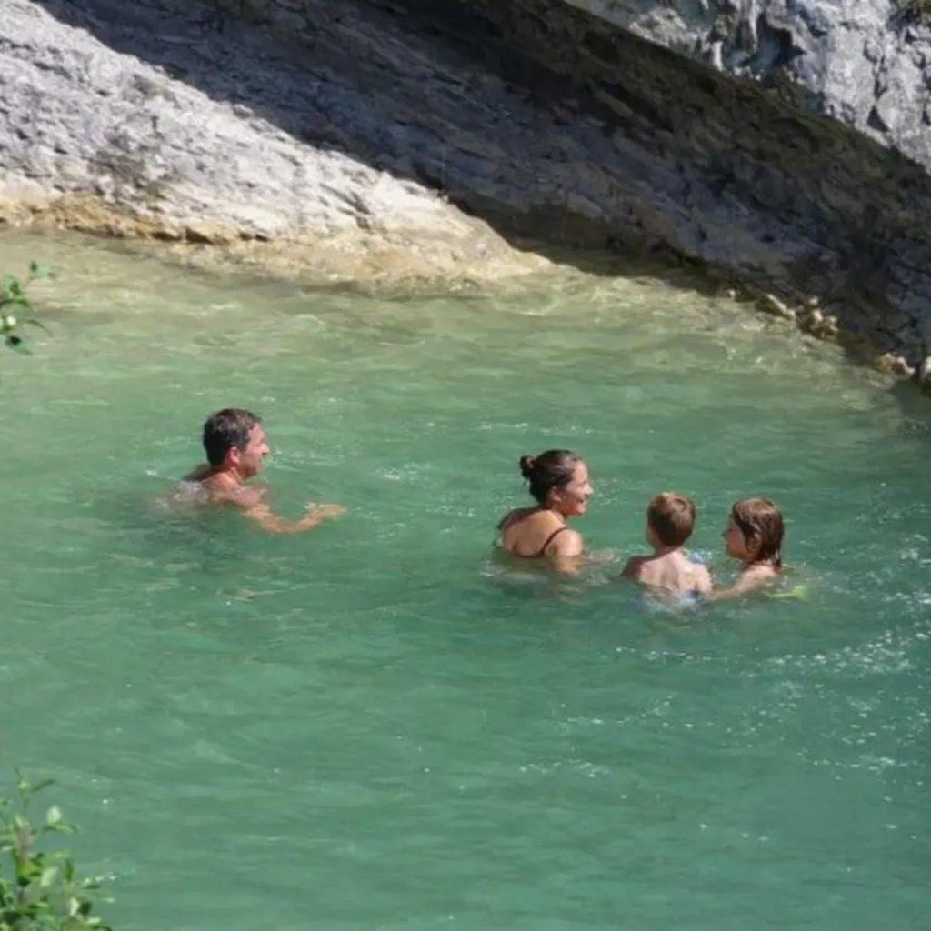 Baignade en famille dans une vasque naturelle aux gorges de Trente-Pas, avec une eau verte et fraîche au pied des rochers.