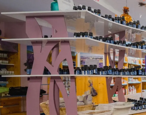 Rayonnages de flacons autour d’une structure rose dans la boutique de la distillerie.