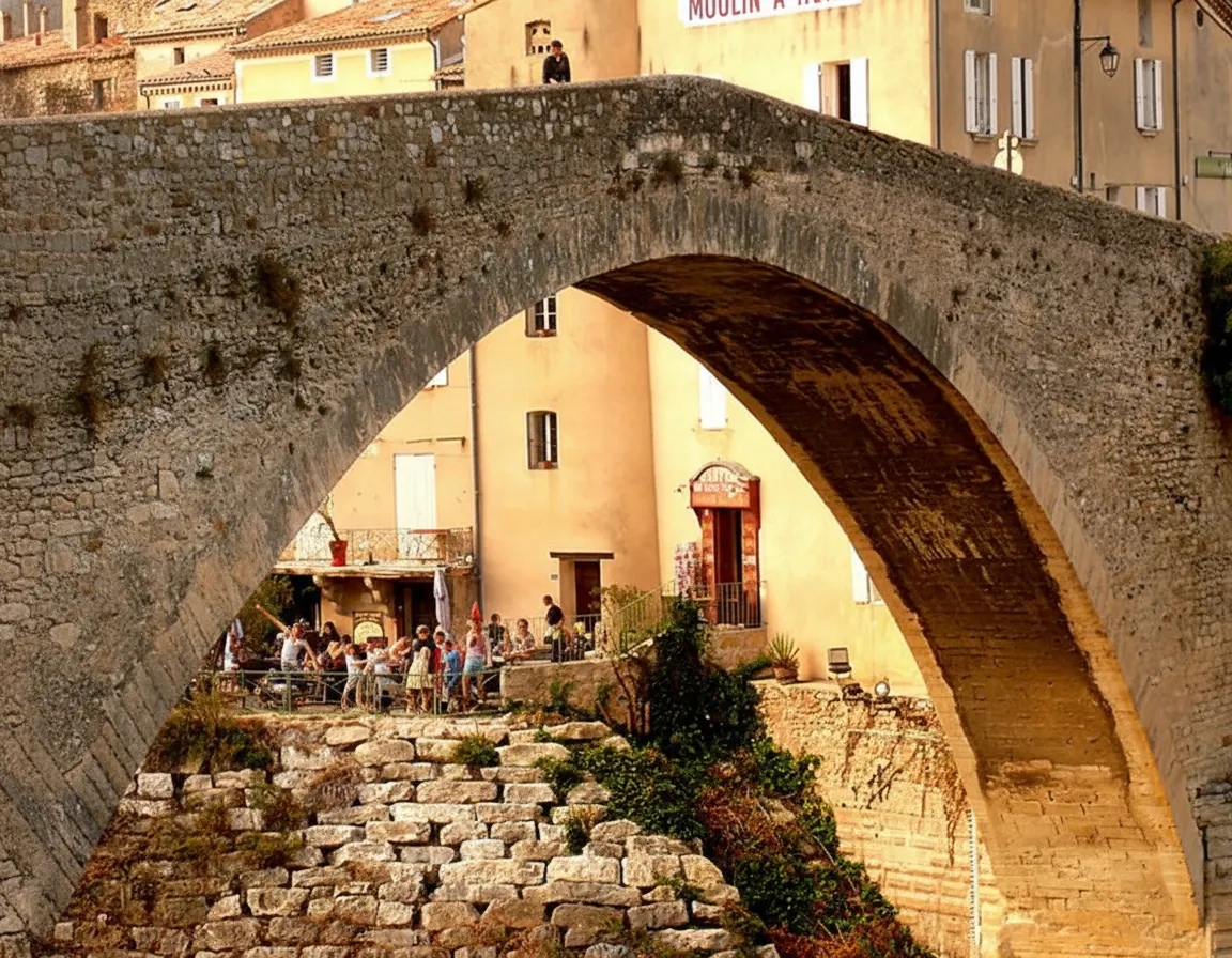 Arche du Pont Roman de Nyons devant des maisons et une terrasse.