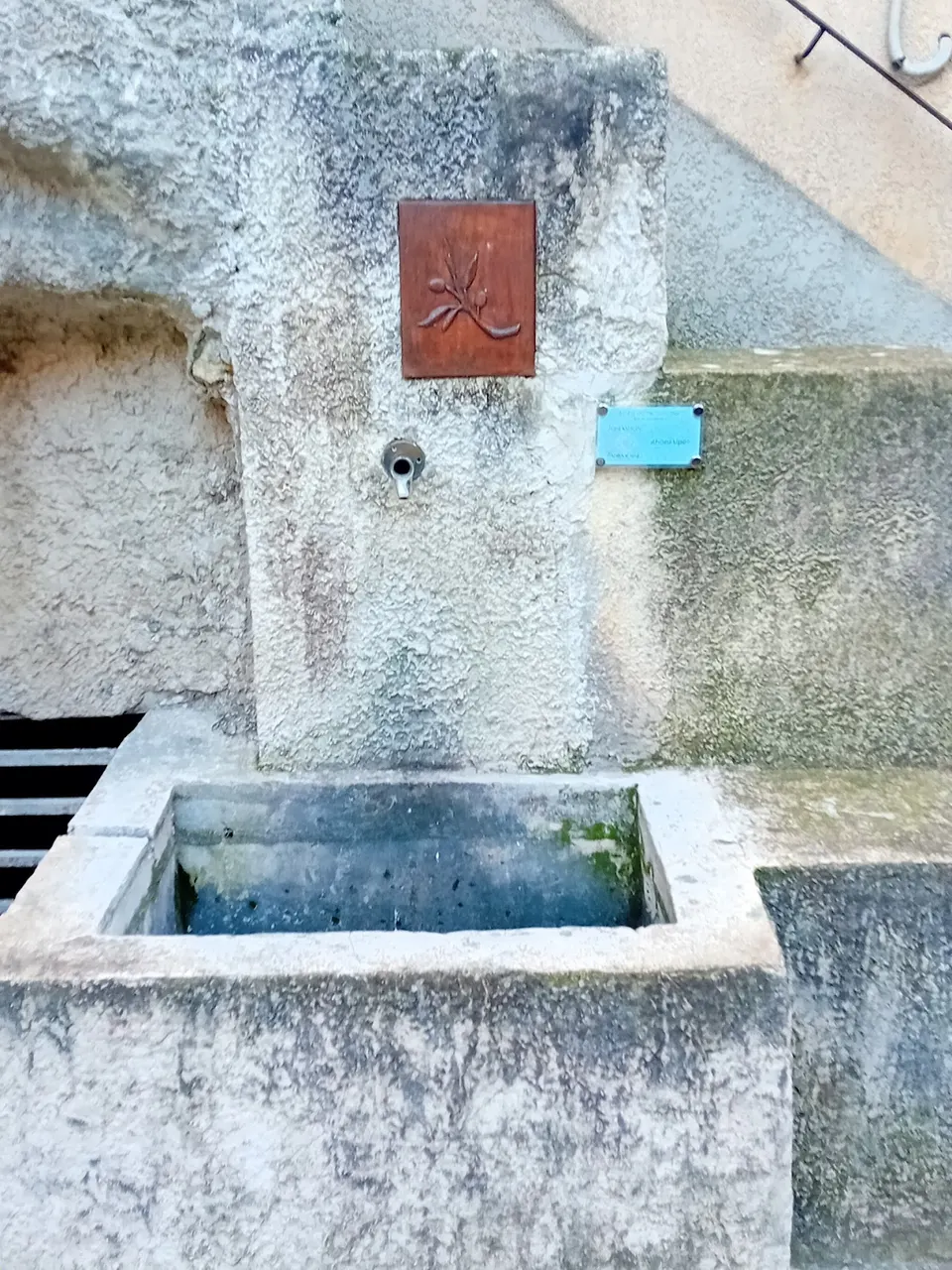 Ancienne fontaine en pierre dans une ruelle du vieux Nyons