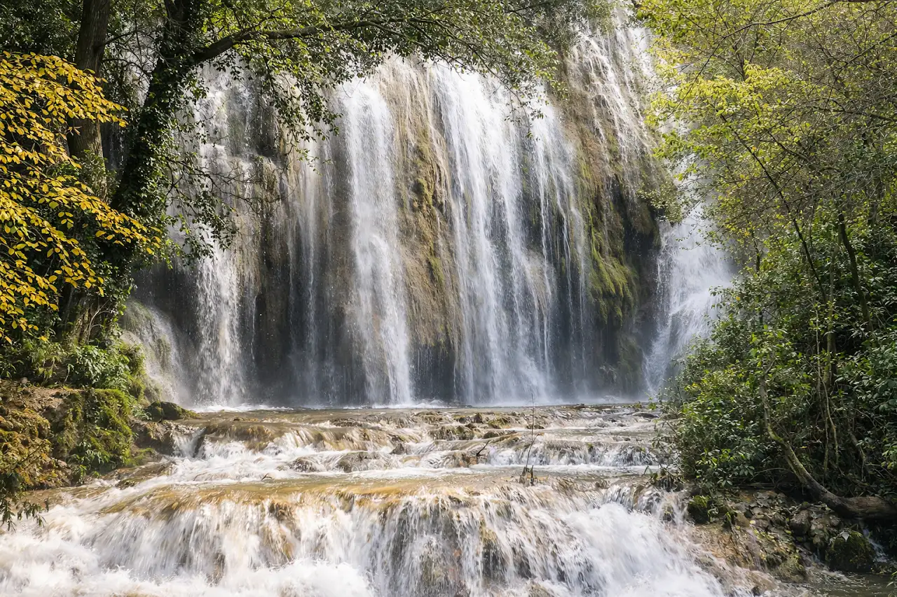 Cascade d’Aubres avec fort débit d’eau, chutes en escalier et végétation dense, après les pluies.