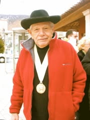 Portrait présenté comme celui de Freddy Tondeur, avec chapeau noir, veste rouge et médaille des Chevaliers de l’Olivier.