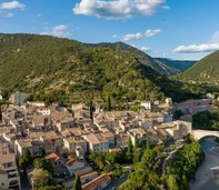 Les toits de Nyons au pied des collines boisées, avec l’Eygues sur la droite.