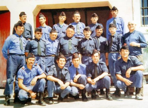 Groupe de pompiers de Nyons en tenue bleue devant les portes de la caserne.