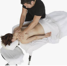 Un professionnel effectue des soins manuels du dos sur une patiente allongée.
