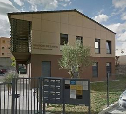 Vue d’ensemble de la Maison de Santé Émile Lisbonne à Nyons, derrière le portail et les panneaux d’information.