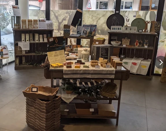 Présentoirs en bois et produits dans la boutique de la Maison des Huiles et Olives de France.
