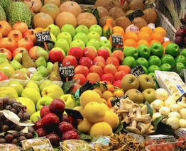 Étal de pommes, agrumes, poires et autres fruits, avec des étiquettes de prix.