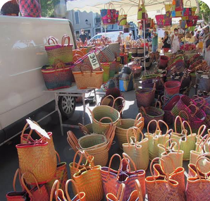 De nombreux paniers tressés aux bordures colorées exposés sur un stand de marché.