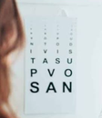 Tableau de lettres utilisé pour un test d’acuité visuelle, face à une patiente.