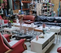 Canapés, fauteuils et tables d’occasion exposés dans une ressourcerie.