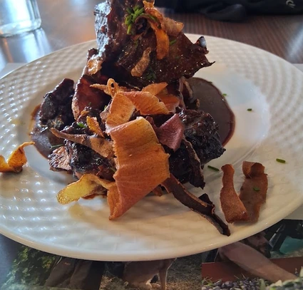 Pièce de viande en sauce garnie de copeaux de légumes, au Café de la Bourse à Nyons.
