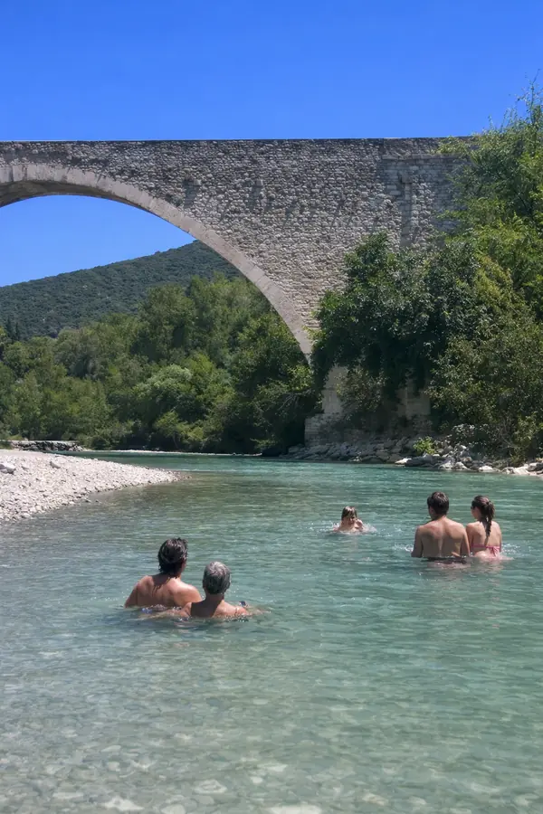 Baigneurs sous l’arche du Pont Roman de Nyons, dans l’eau claire de l’Eygues.