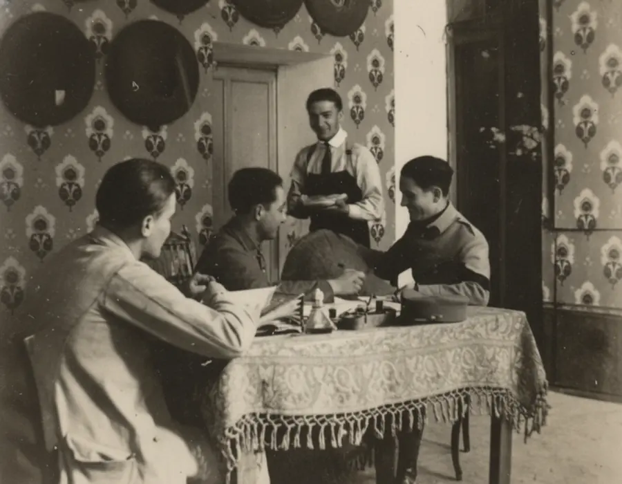 Photographie ancienne en noir et blanc montrant une famille autour d’une table.