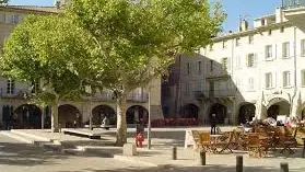 Place des Arcades à Nyons, avec ses platanes, ses terrasses et ses façades à arcades.