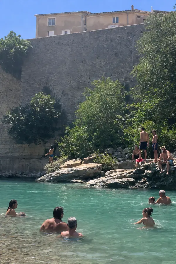 Baigneurs dans l’Eygues au pied du mur en pierre près du Pont Roman de Nyons.