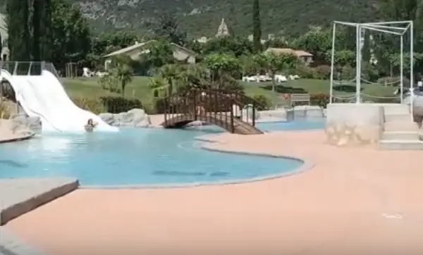 Bassin extérieur de Nyonsoleïado et toboggan blanc au bord de l’eau.