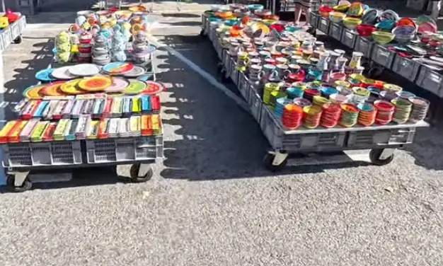 Étals de vaisselle et d’ustensiles colorés au marché de Nyons.