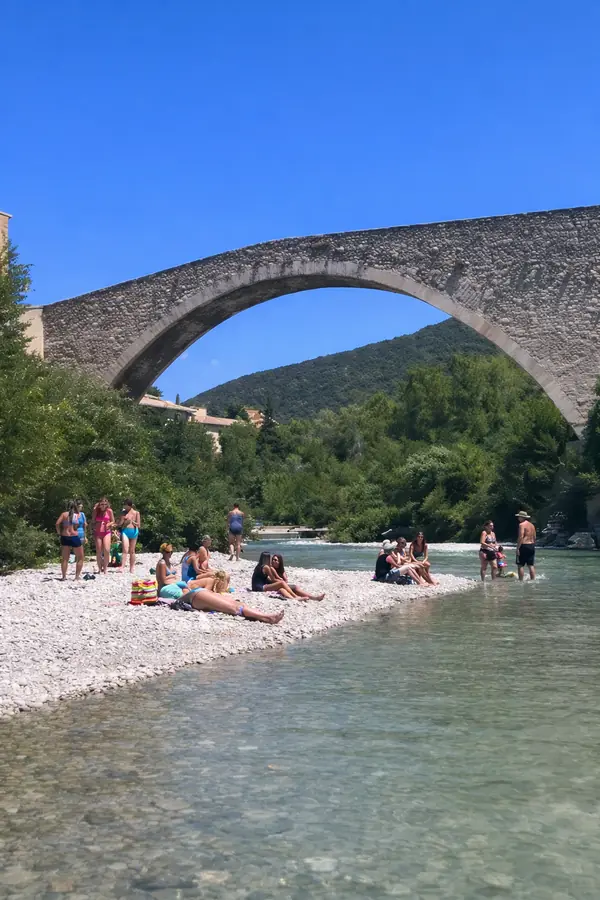 Familles sur la plage de galets et dans l’Eygues, sous le Pont Roman de Nyons.