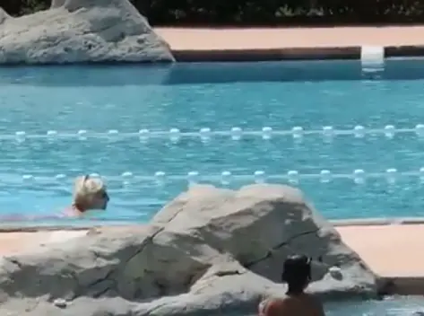 Nageuse dans un bassin de Nyonsoleïado, derrière les rochers décoratifs.